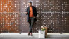 Man standing in front of a wall with a few shopping bags
