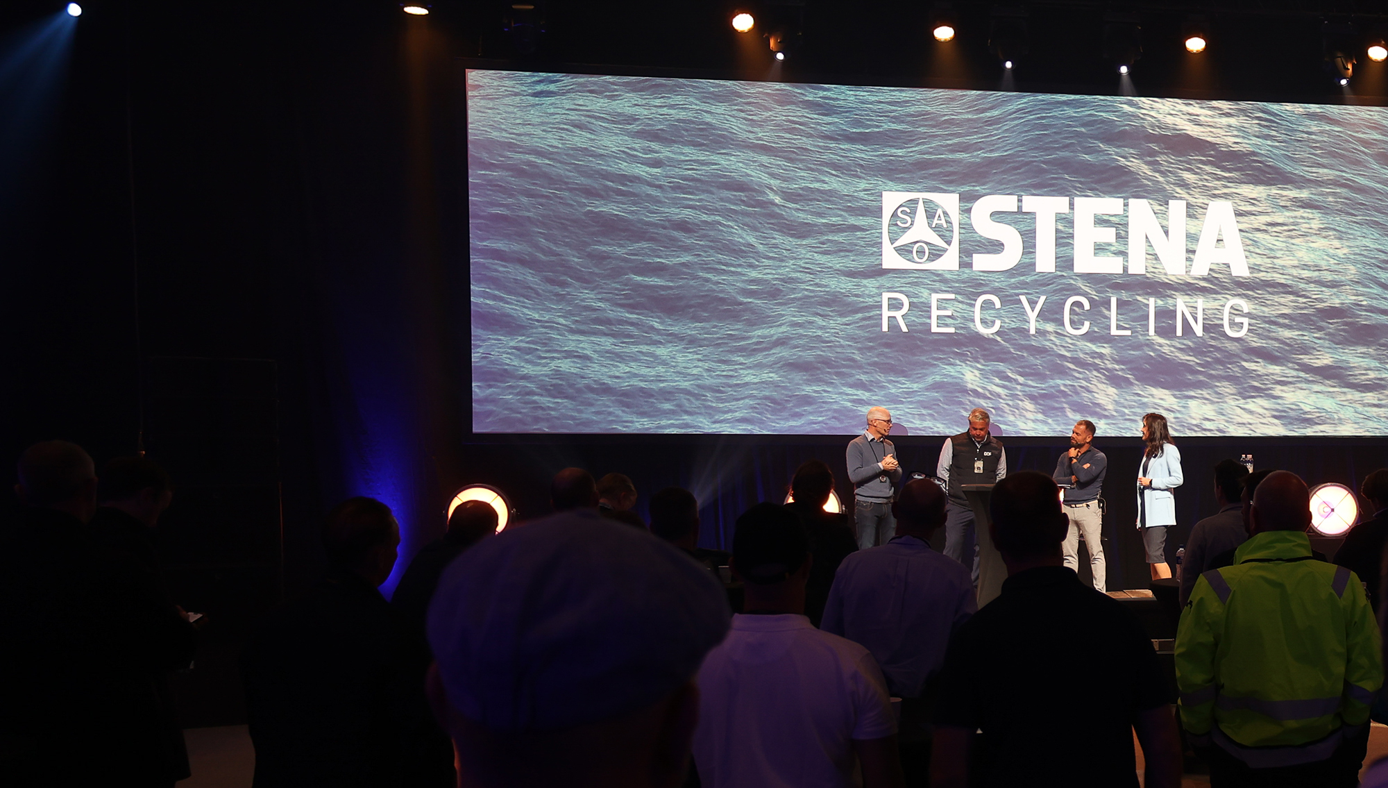 people on a stage in front of a backdrop