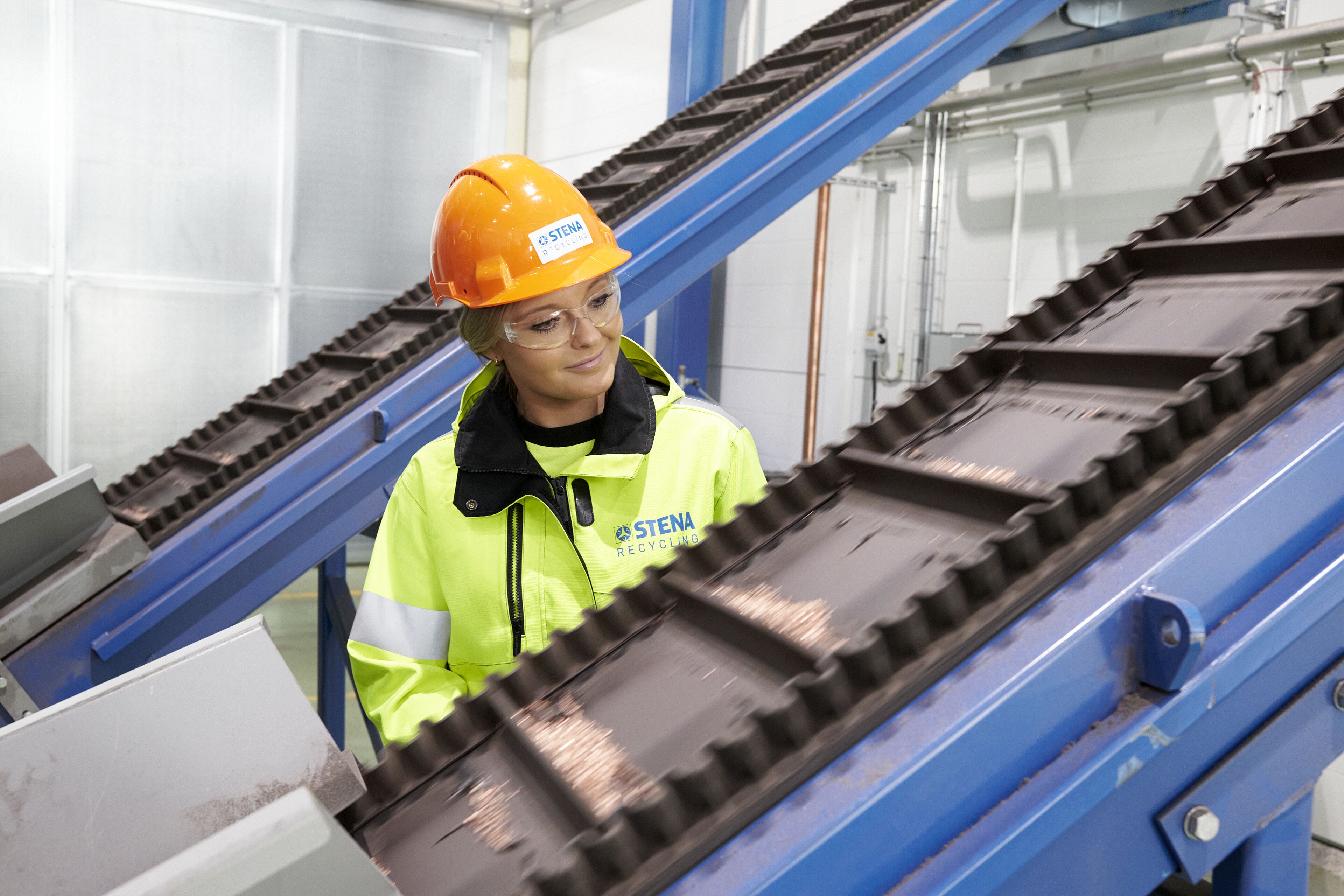 Kvinna vid rullande band i produktionsmiljö