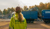 En Stena Recycling anställd i varselkläder vid blå container