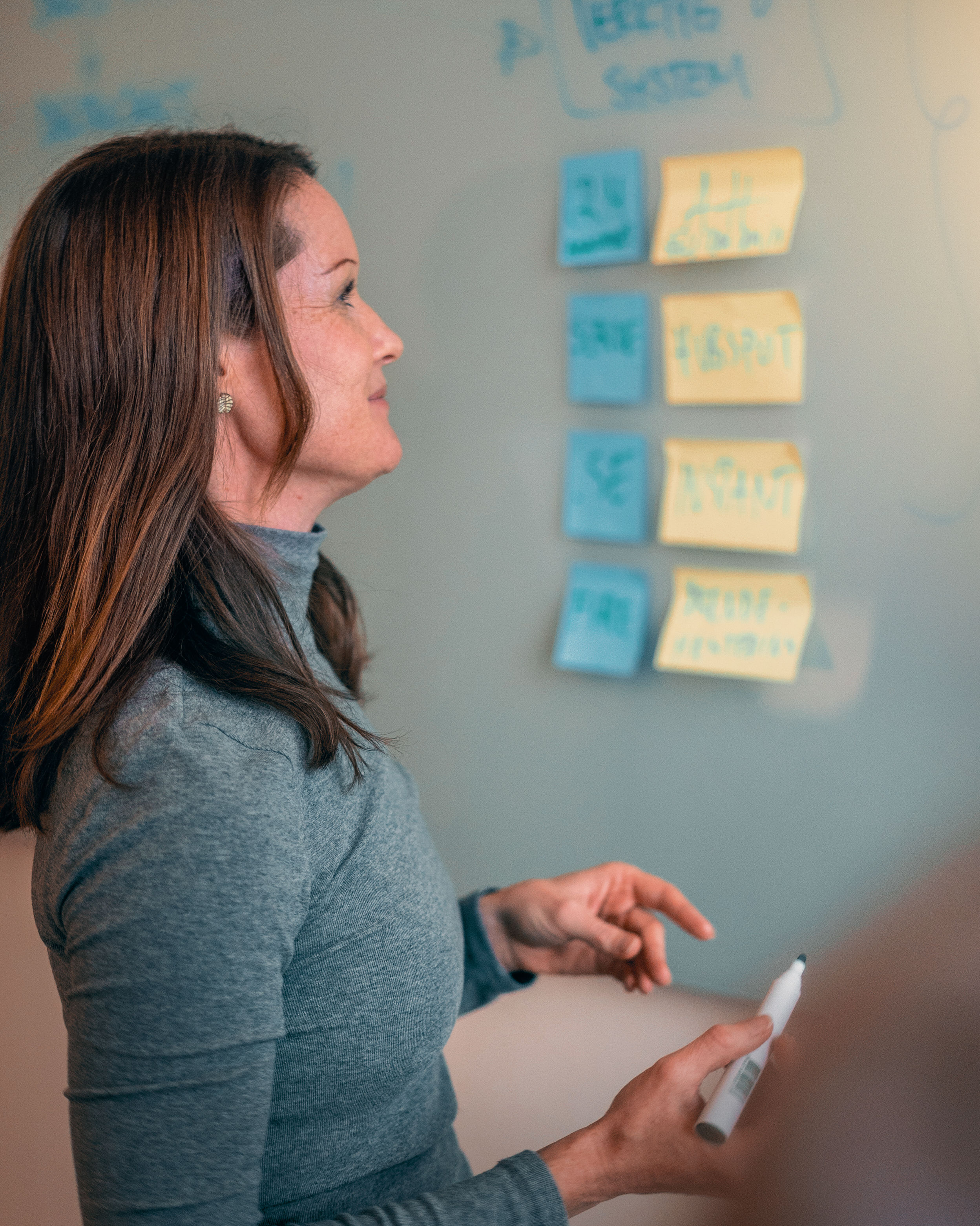 Kvinna framför tavla med post-its