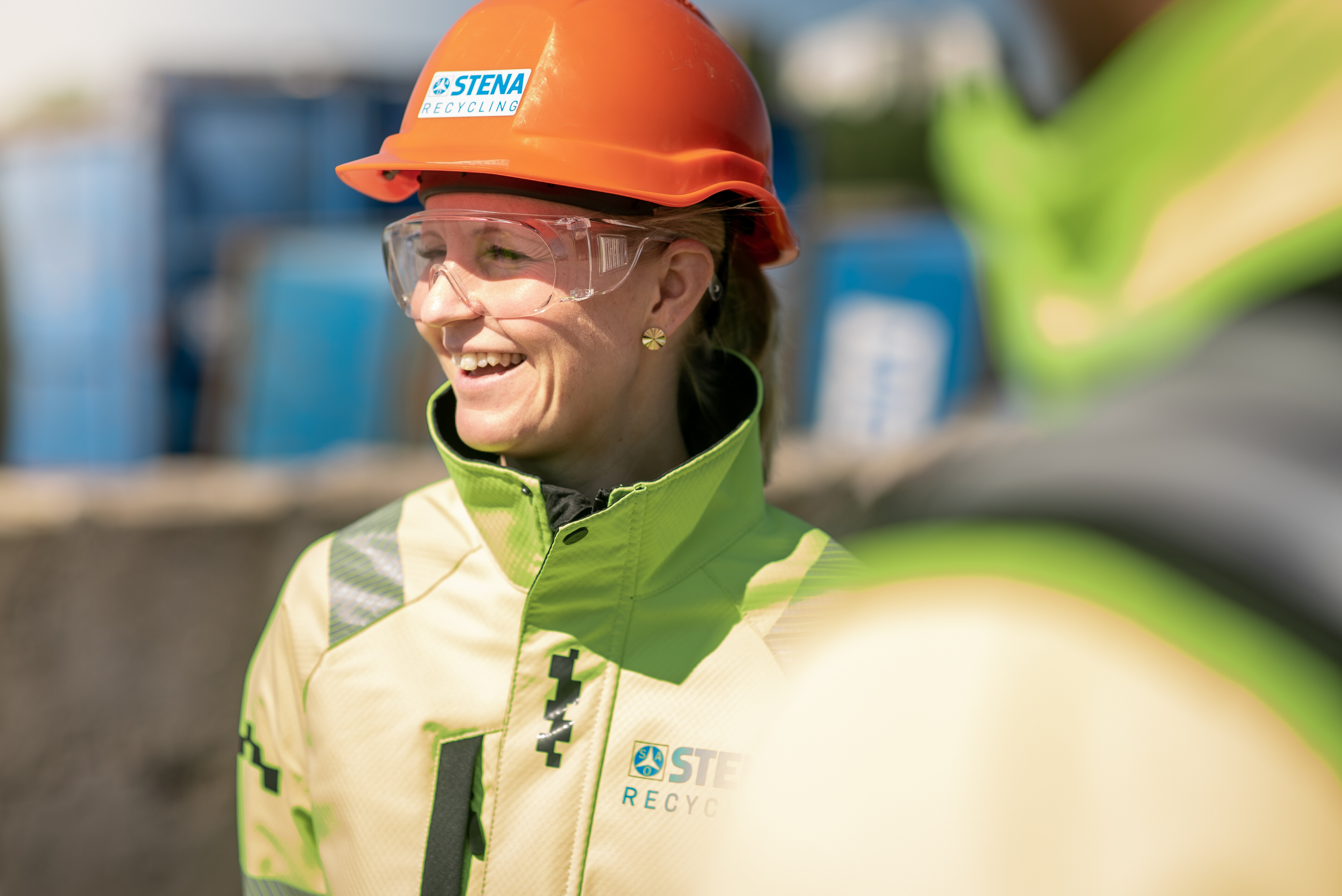 Stena Recycling employee in protective, hi-vis gear in a scrap yard.