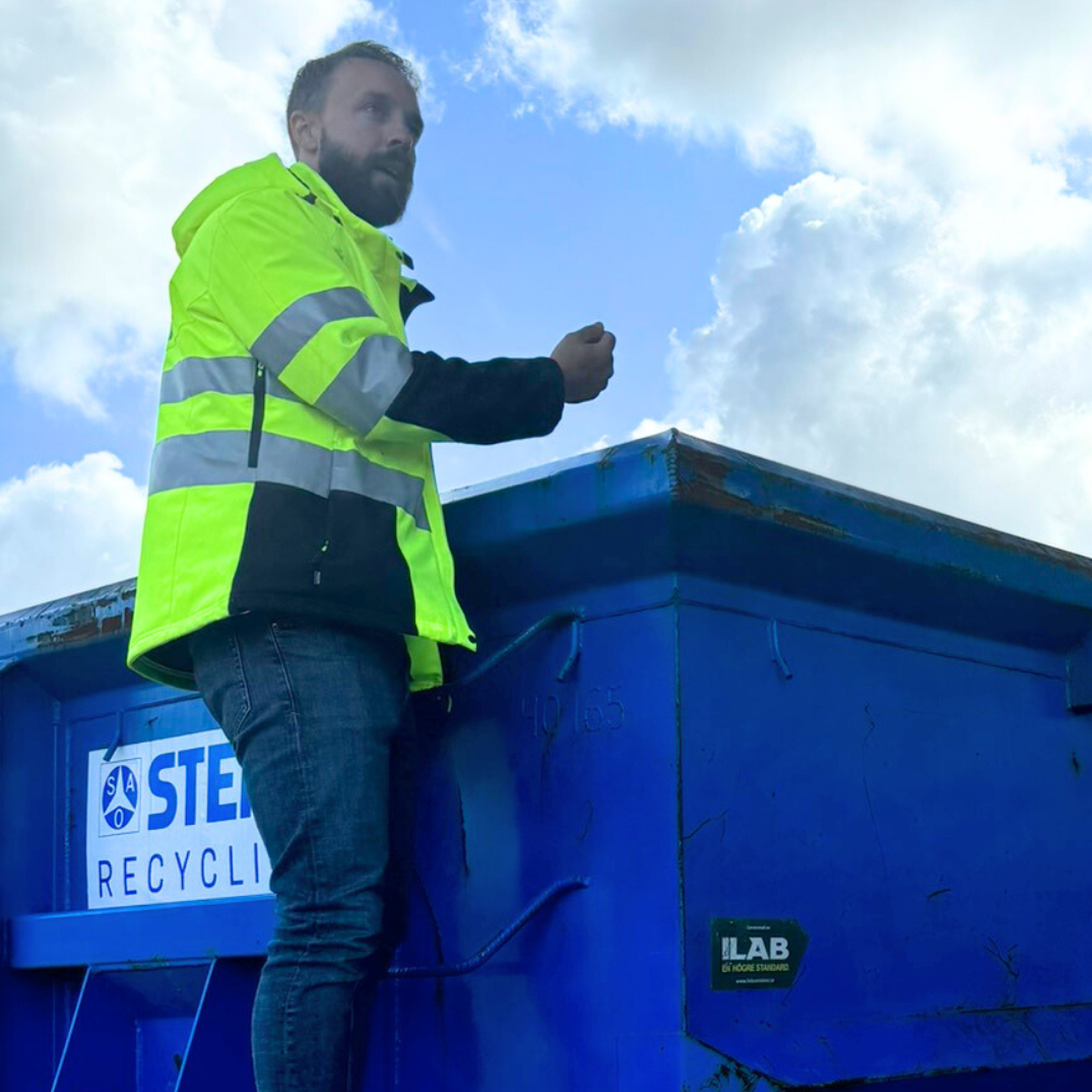 Varselklädd person vid container