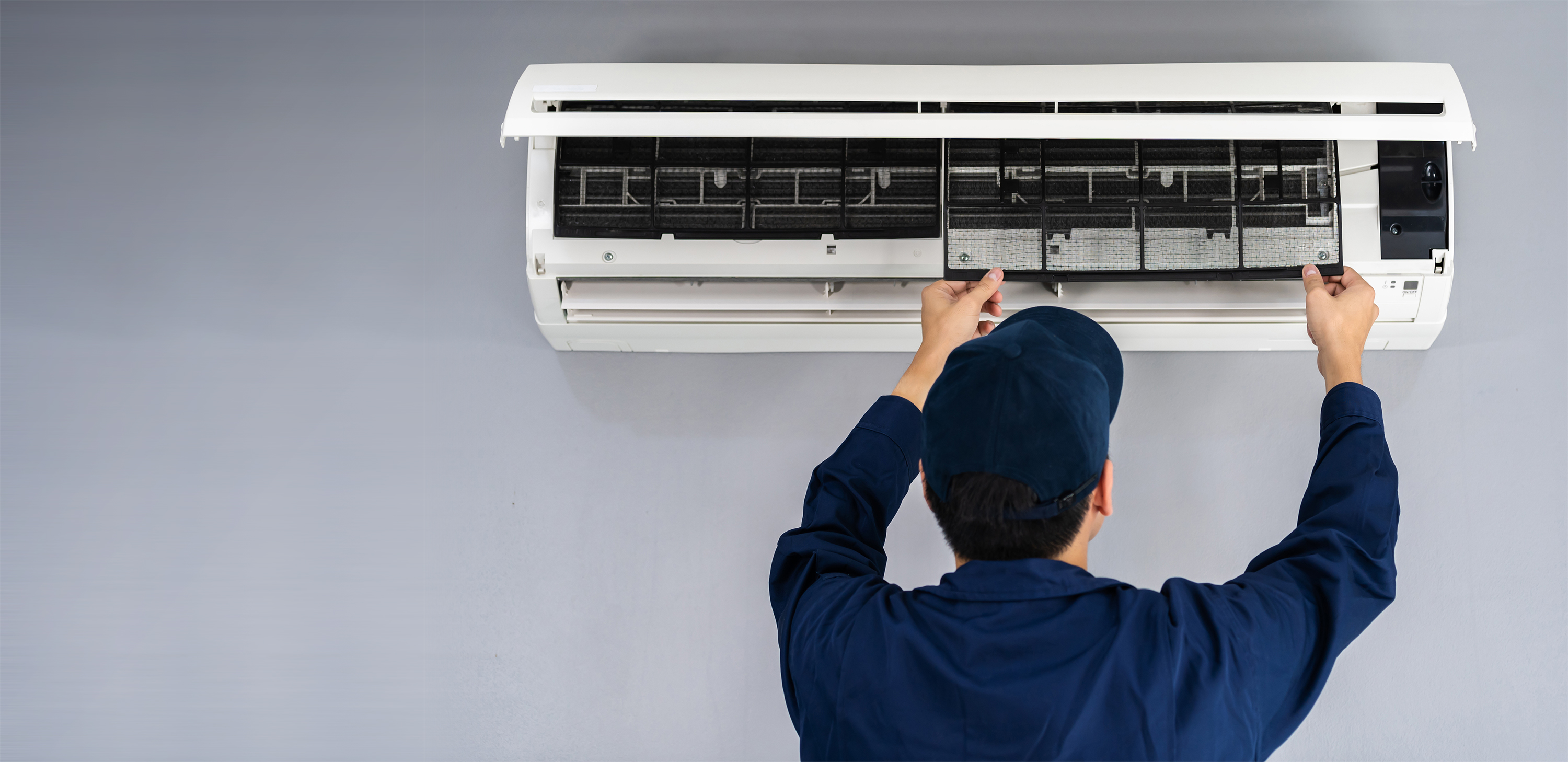 A man working to repair an air conditioning unit.
