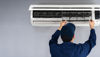 A man working to repair an air conditioning unit.