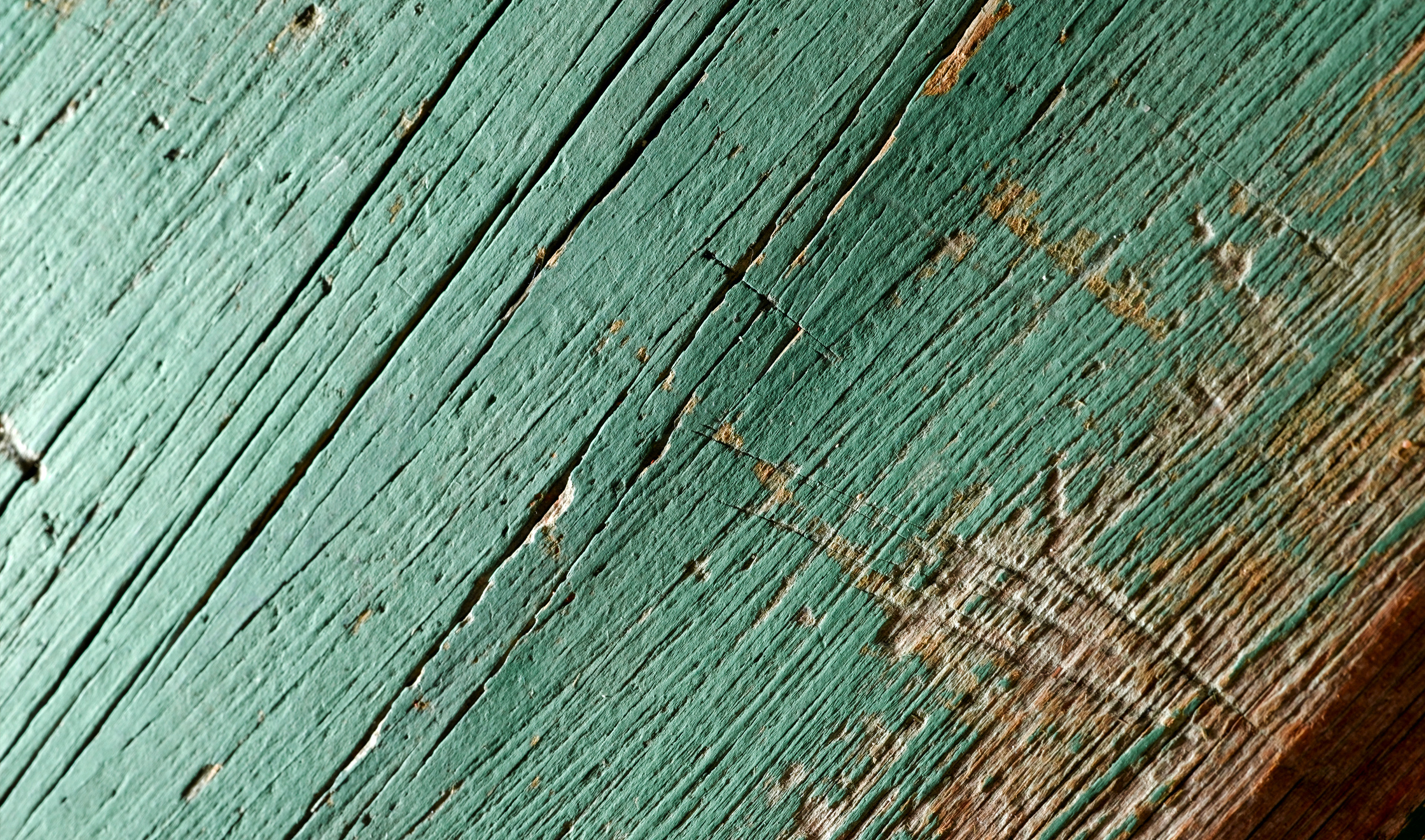 Close-up of a worn, green-painted piece of waste wood ready for recycling