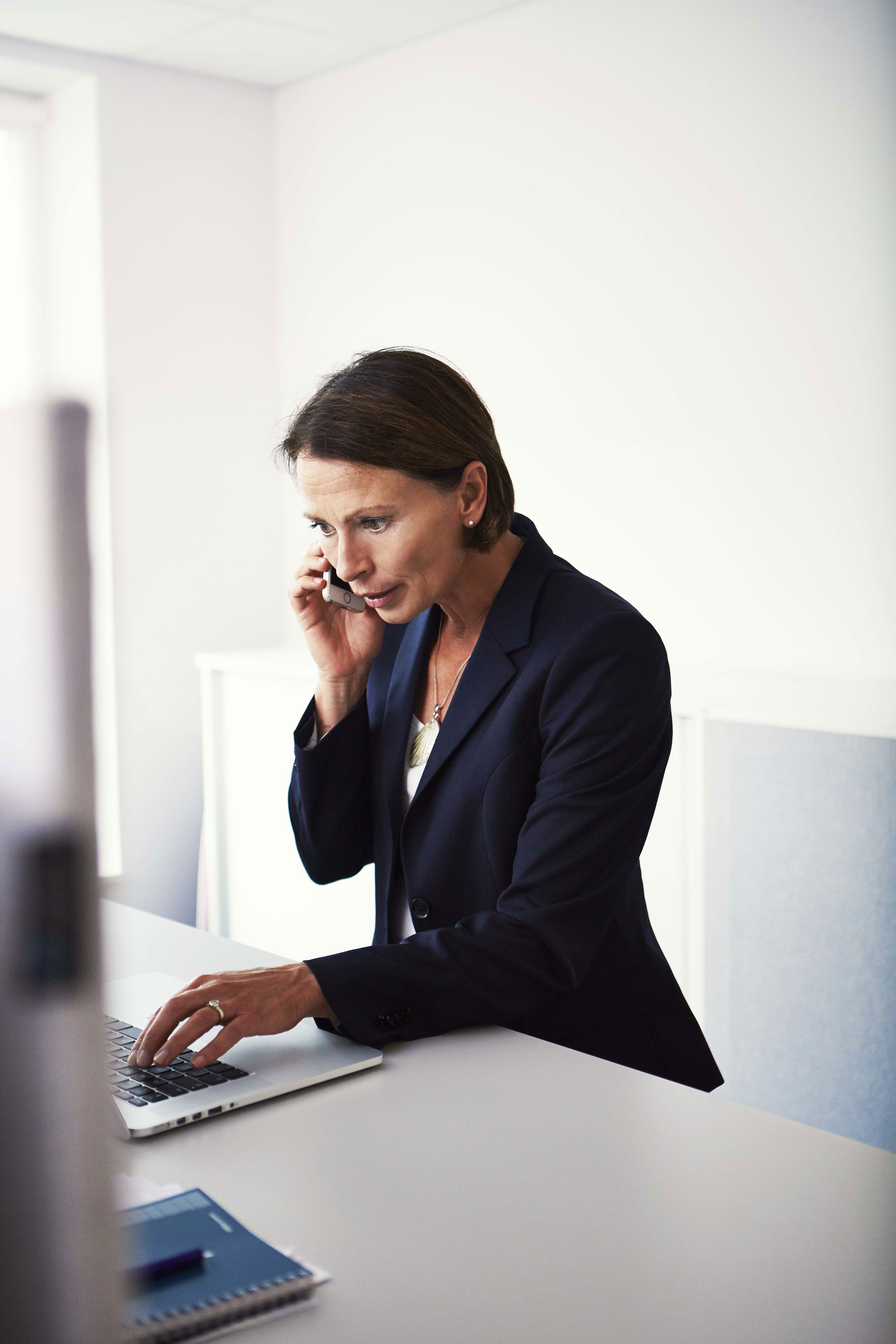 A close-up of a Stena Recycling employee's hand as they work at a laptop in an office.