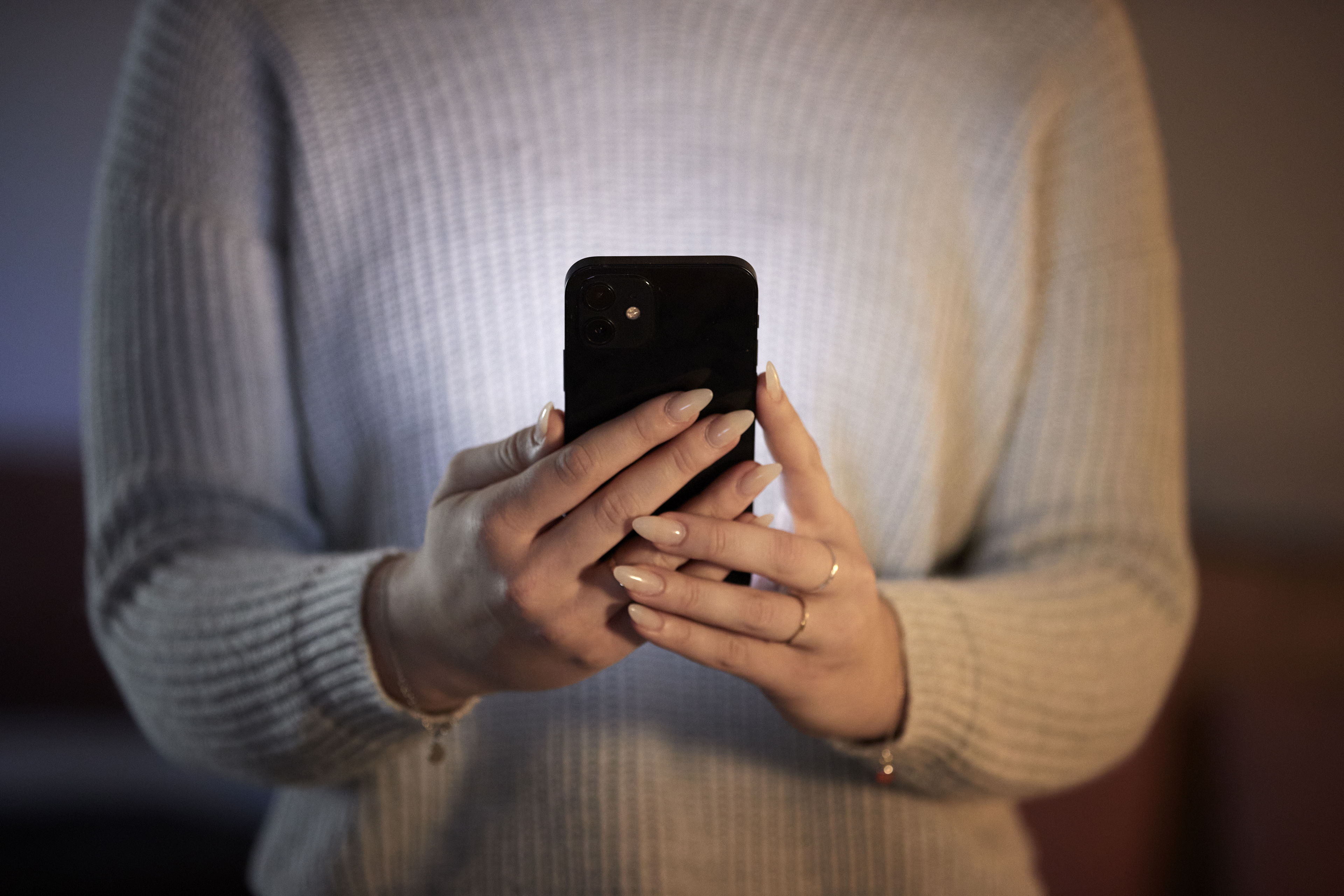 A person holding a mobile phone and texting