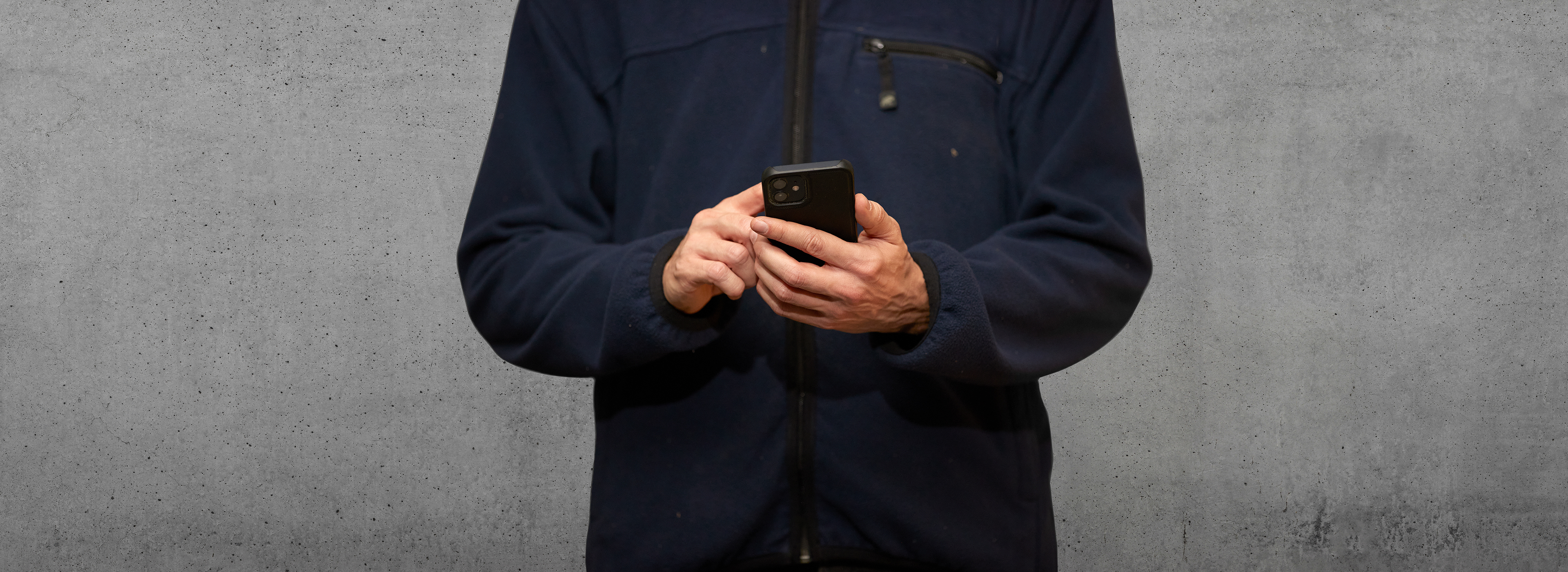 Henkilö tutkimassa kännykällä asiakasportaalin raportointia