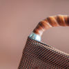A close-up image of a black faux leather texture featuring a metallic zipper with gold teeth.
